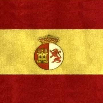 An old Spanish flag in red and yellow stripes with a crowned coat of arms showing a castle and a lion.