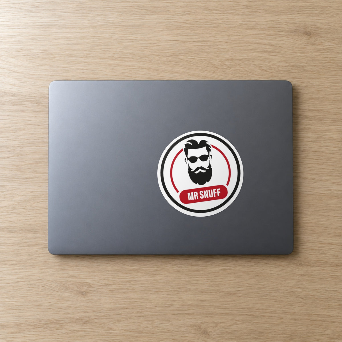 Mr Snuff 110 mm round sticker on a laptop lid
